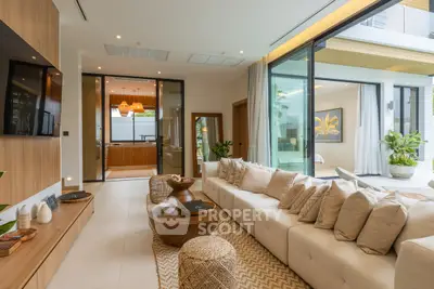 Luxurious modern living room with elegant decor and large sliding glass doors opening to a serene outdoor space.