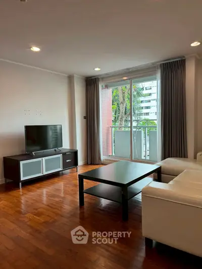 Spacious living room with modern furniture and balcony view in urban apartment.
