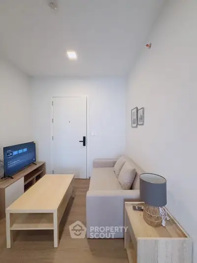 Modern living room with cozy sofa, wooden coffee table, and flat-screen TV in a stylish apartment.