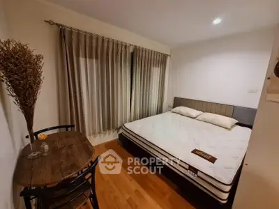 Cozy bedroom with large bed and wooden table, perfect for relaxation.