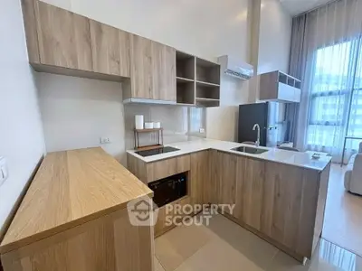 Modern kitchen with wooden cabinets and sleek appliances in a bright apartment