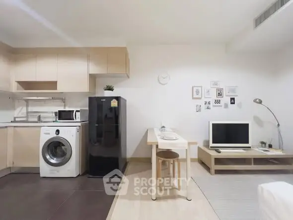 Modern open-layout kitchen and living area with appliances and stylish decor.