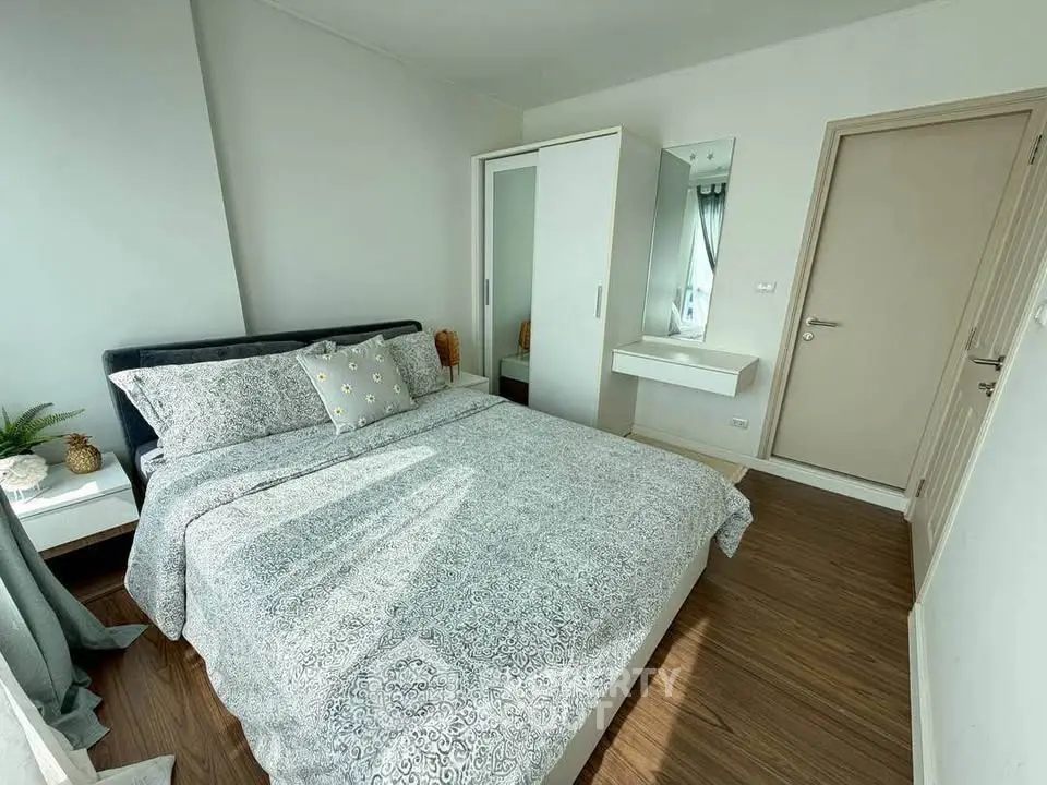 Cozy bedroom with modern decor and ample natural light, featuring a comfortable bed and stylish wardrobe.