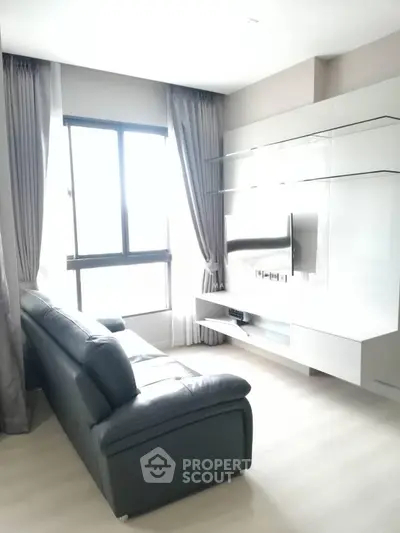 Modern living room with sleek furniture and large window for natural light.