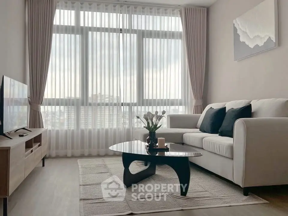 Modern living room with large windows, stylish furniture, and elegant decor.