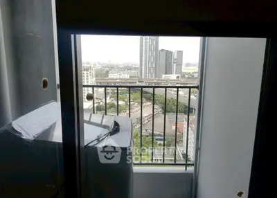 High-rise apartment balcony with cityscape view and washing machine.