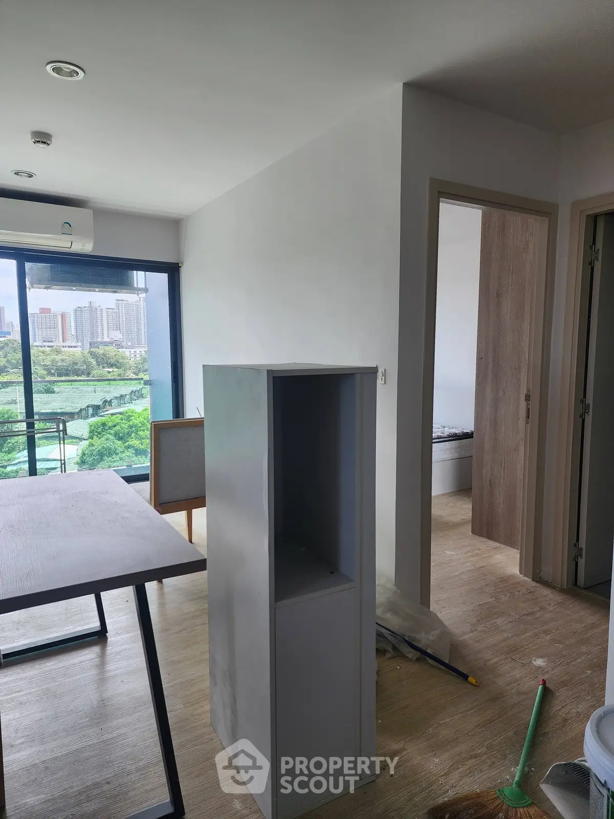 Modern apartment interior with city view, featuring open layout and natural light.