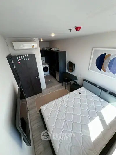 Modern bedroom with stylish decor and in-room washing machine, perfect for urban living.