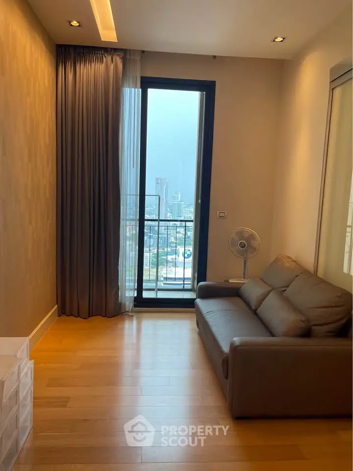 Cozy living room with city view, featuring a comfortable sofa and elegant wooden flooring.