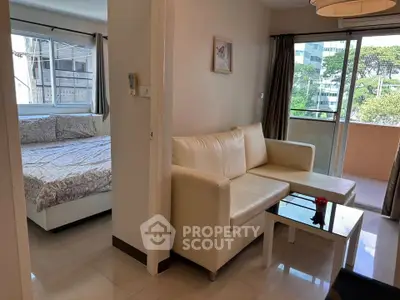 Modern apartment with cozy living room and bedroom, featuring a balcony with city view.