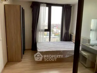 Cozy bedroom with city view, featuring a single bed and modern furnishings, perfect for urban living.