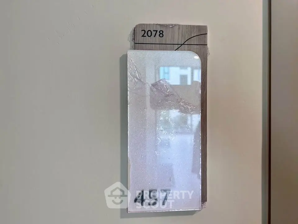 Modern apartment door number 457 with sleek design and reflective surface.