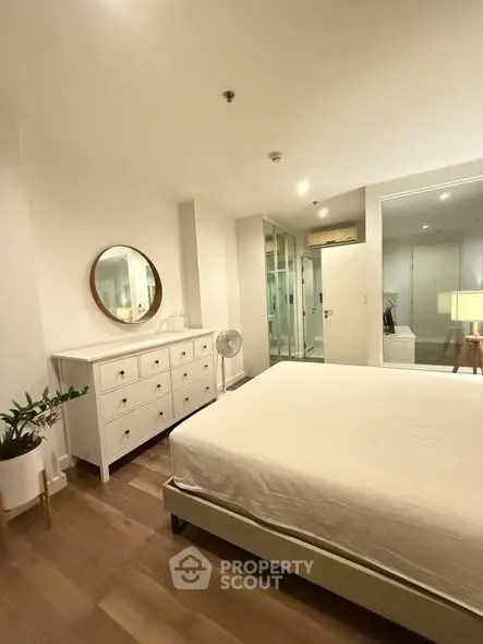 Spacious modern bedroom with elegant decor and ample natural light.