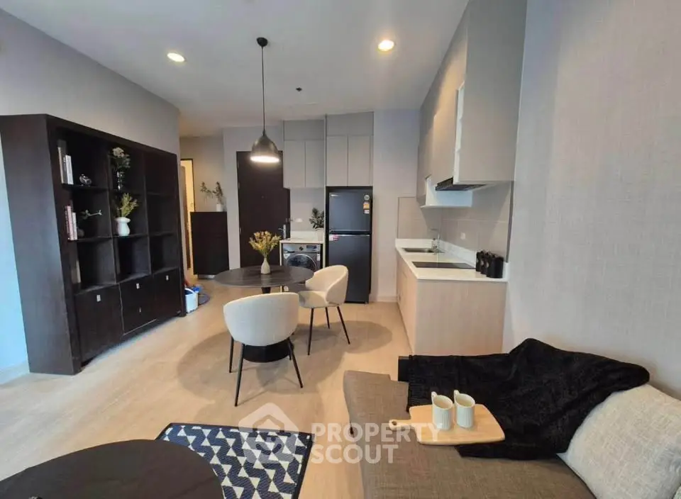 Modern open-layout living room with kitchen, stylish furniture, and cozy decor in a contemporary apartment.