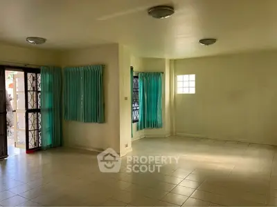 Spacious living room with tiled flooring and natural light, ideal for modern living.