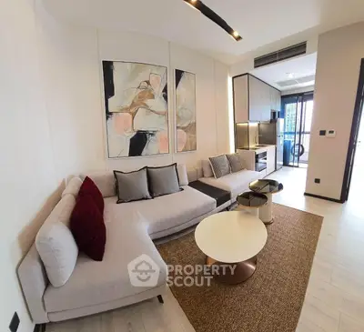 Modern living room with stylish sectional sofa, abstract art, and open layout leading to balcony.