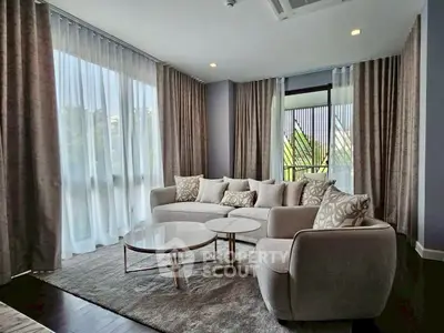 Elegant living room with large windows and stylish furniture, perfect for modern living.