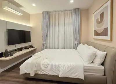 Modern bedroom with elegant decor and wall-mounted TV, featuring cozy bed and stylish curtains.