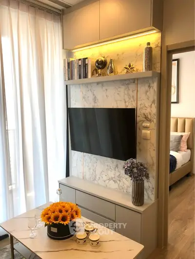Modern living room with marble TV wall and elegant decor in a stylish apartment.