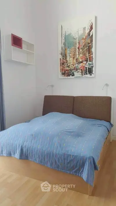 Cozy bedroom with modern art and stylish bedding in a bright apartment.