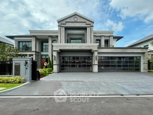 Luxurious modern mansion with grand entrance and spacious driveway, showcasing elegant architectural design.