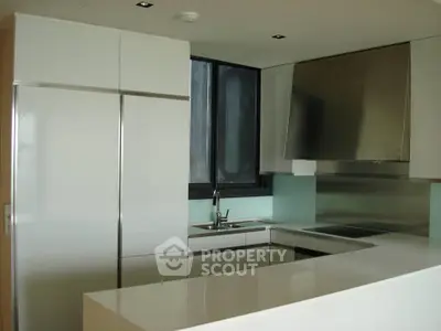 Modern kitchen with sleek white cabinetry and stainless steel appliances