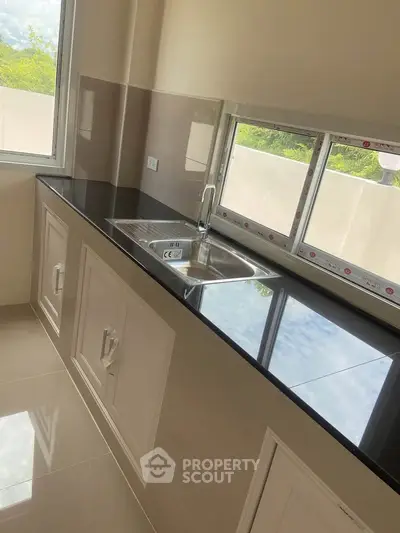 Modern kitchen with sleek black countertop and stainless steel sink