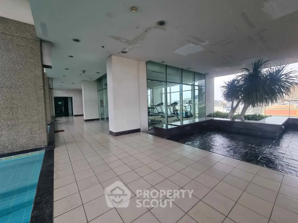 Spacious gym area with poolside view in modern building