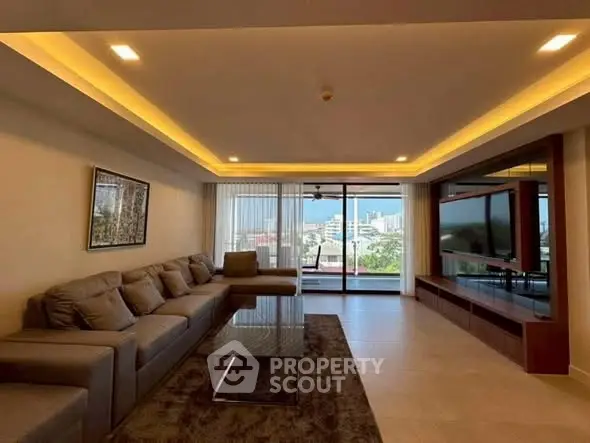 Spacious living room with modern decor and city view balcony.