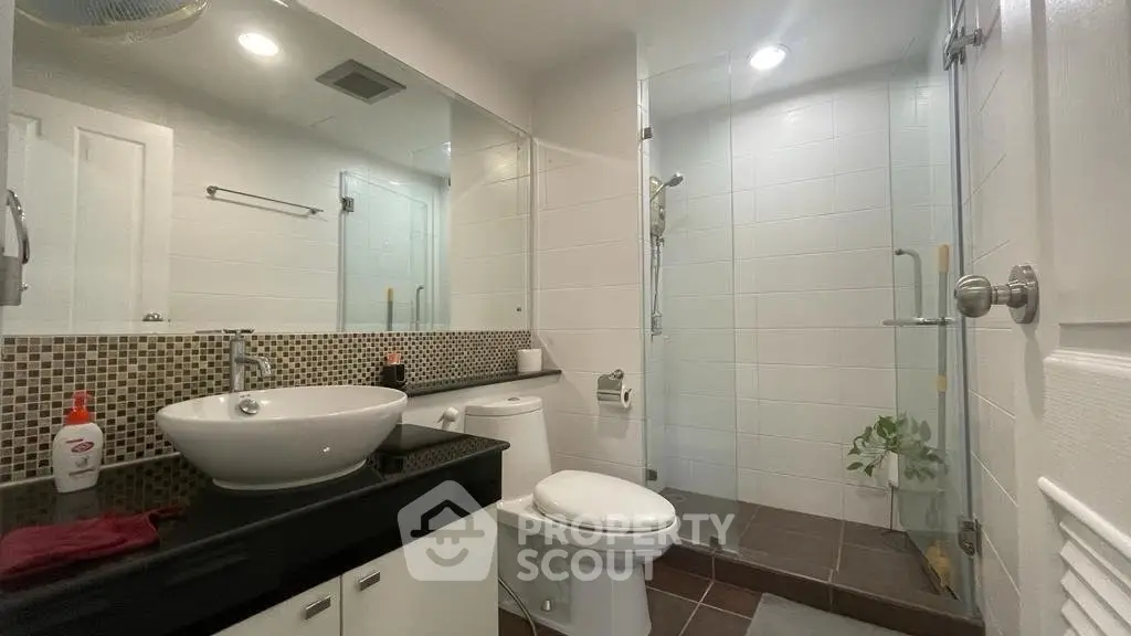 Modern bathroom with sleek fixtures and glass shower enclosure