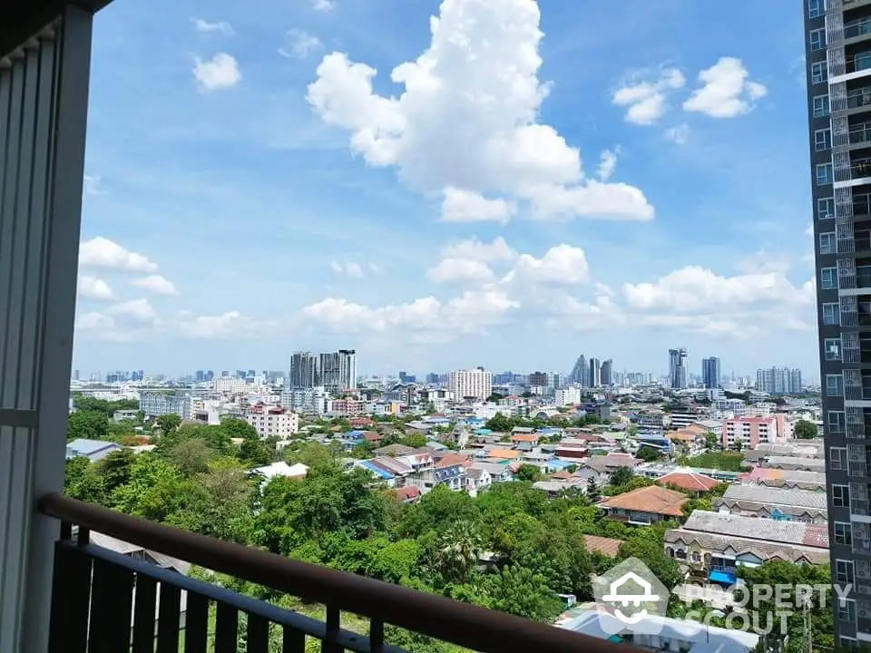 Stunning cityscape view from a high-rise balcony with clear blue skies and lush greenery.