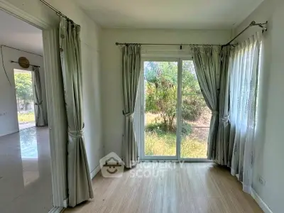 Bright room with large windows and garden view, perfect for a cozy living space.