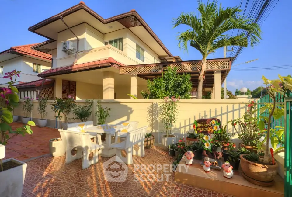 Charming two-story house with spacious patio and lush garden, perfect for outdoor relaxation and entertaining.