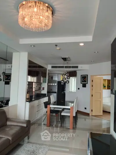 Modern living room with elegant chandelier and open kitchen layout