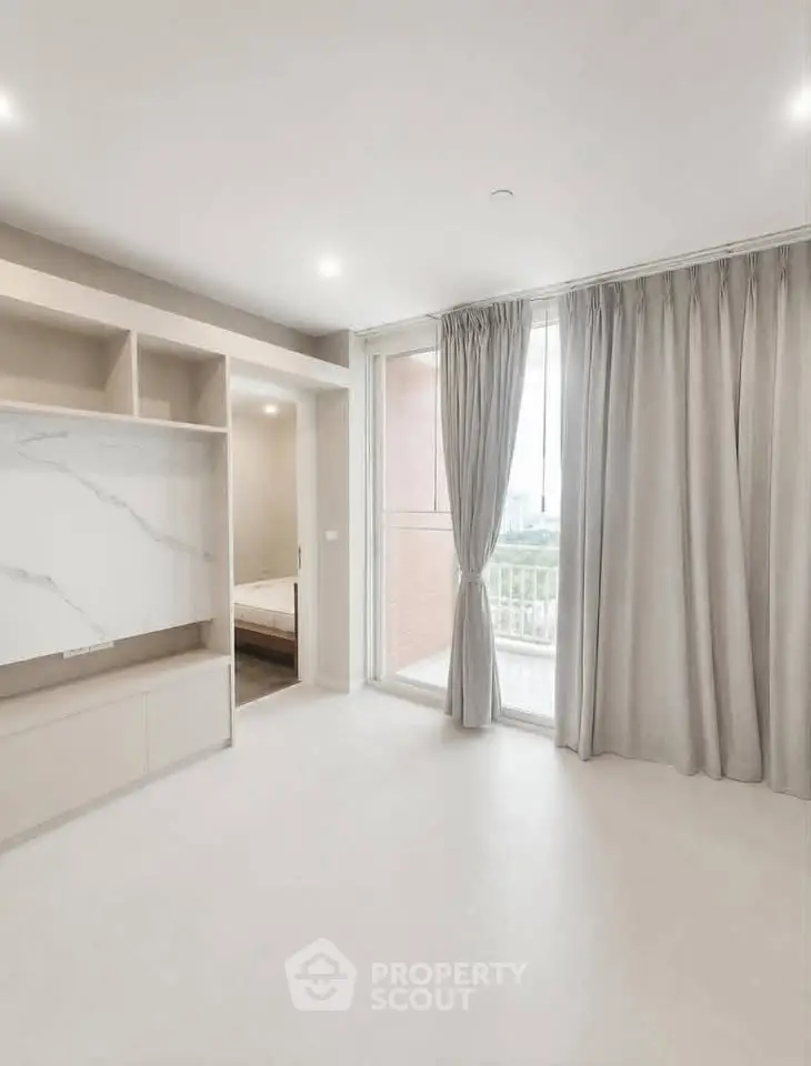 Spacious modern living room with large windows and elegant curtains, offering a serene view.