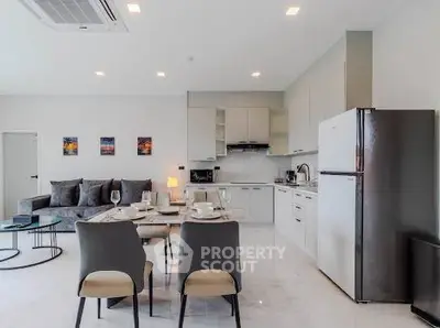 Modern open-plan kitchen and living room with sleek appliances and stylish decor.