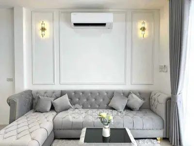 Elegant living room with plush gray sofa and modern air conditioning unit