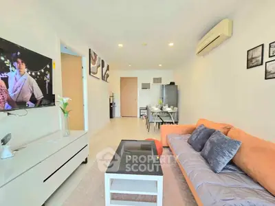 Modern living room with stylish decor, cozy sofa, and wall-mounted TV in a bright apartment.