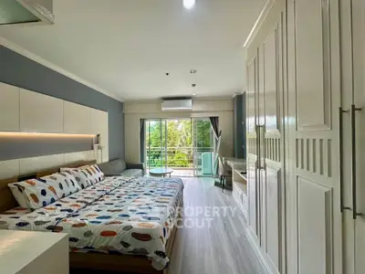 Spacious bedroom with modern decor and balcony view