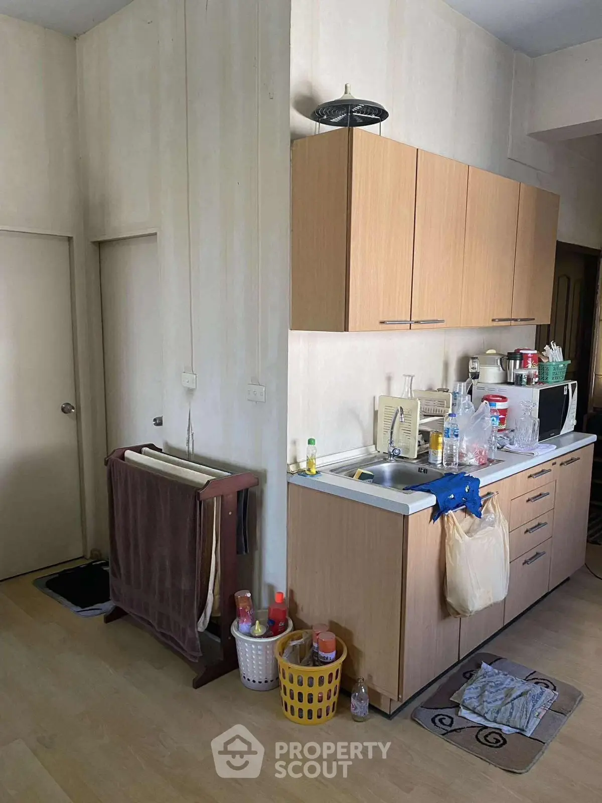 Compact kitchen with wooden cabinets and modern appliances in cozy apartment