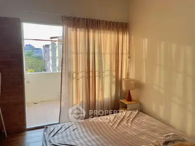 Cozy bedroom with natural light and balcony access in a charming apartment.