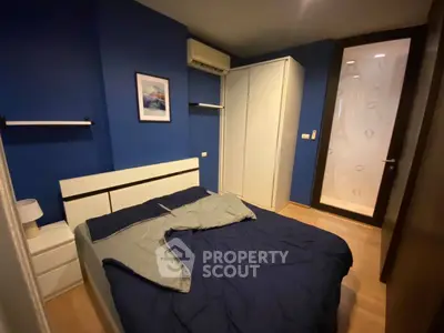 Cozy bedroom with blue walls, modern furniture, and air conditioning unit.