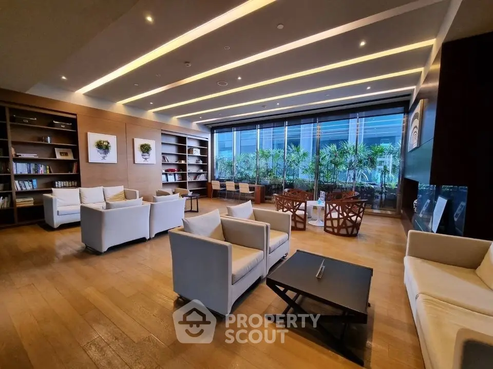 Luxurious modern living room with elegant seating and large windows overlooking greenery.