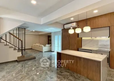 Spacious modern living room with open kitchen and elegant staircase