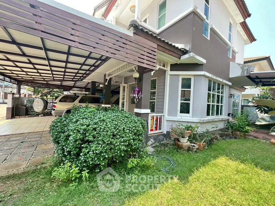 Charming two-story house with carport and lush garden in a serene neighborhood.