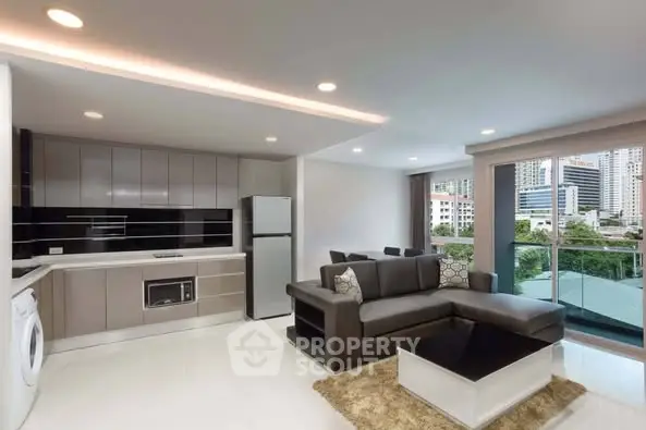 Modern open-layout living room with sleek kitchen and city view balcony.