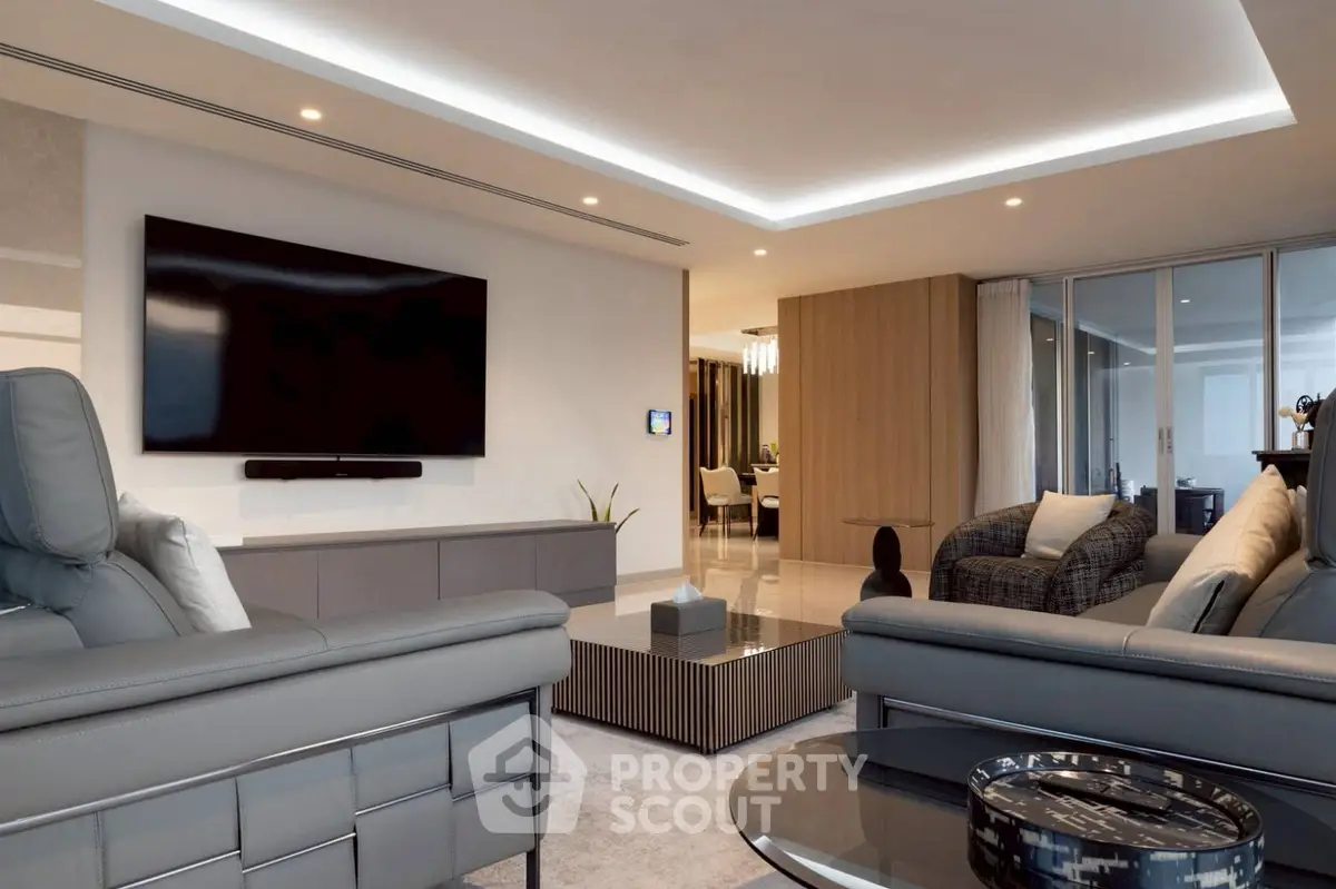 Luxurious modern living room with sleek furniture and large flat-screen TV, perfect for relaxation and entertainment.