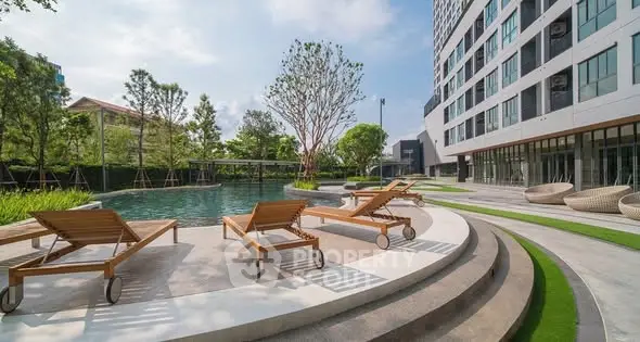Luxurious apartment pool area with sun loungers and modern landscaping.
