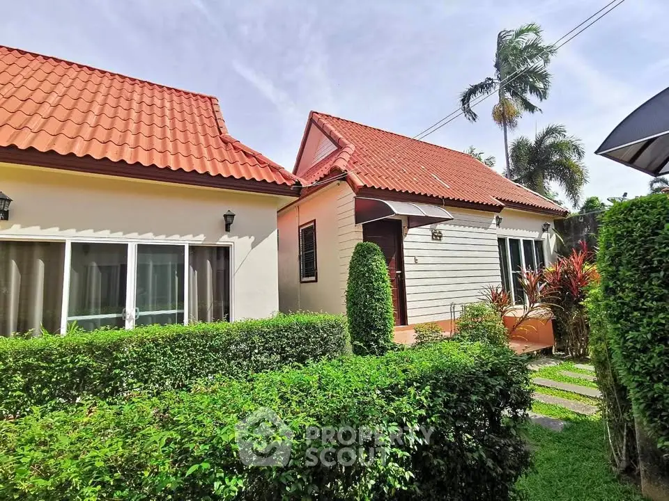 Charming suburban house with red roof and lush garden, perfect for family living.