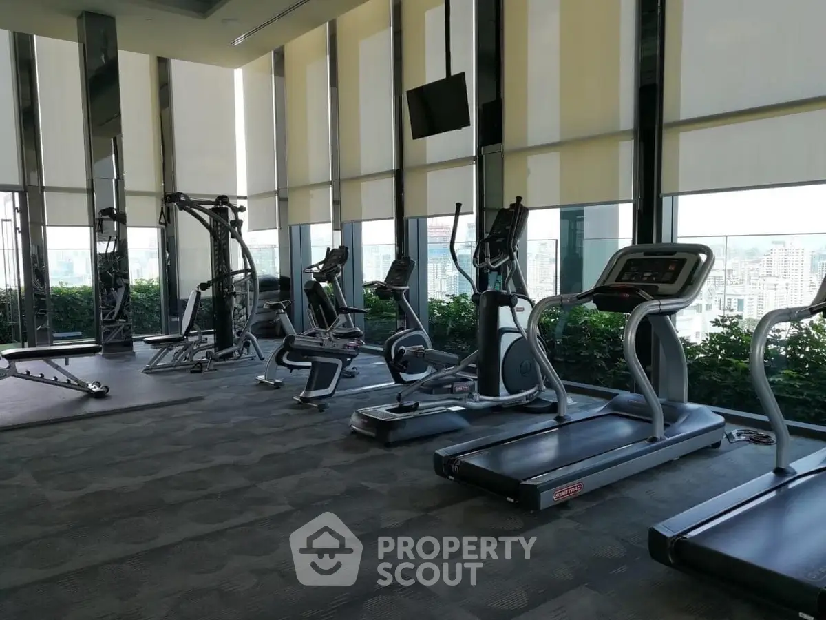 Luxurious high-rise gym with panoramic city views and modern fitness equipment.